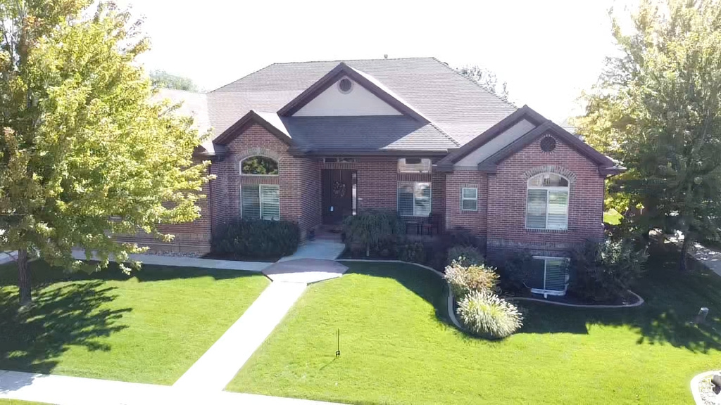 View of front of property with central AC and a front lawn