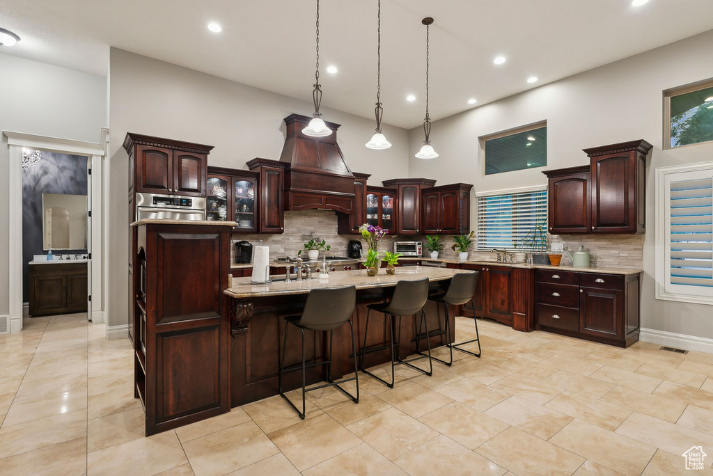 Kitchen with a breakfast bar, a towering ceiling, plenty of natural light, and a spacious island