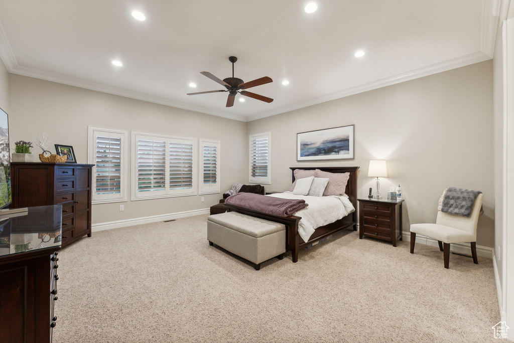 Bedroom featuring ornamental molding, light carpet, and ceiling fan