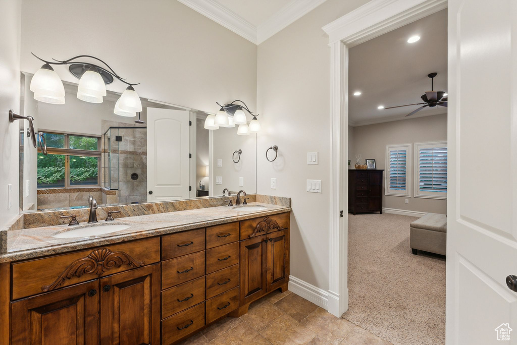 Bathroom with crown molding, vanity, ceiling fan, and an enclosed shower