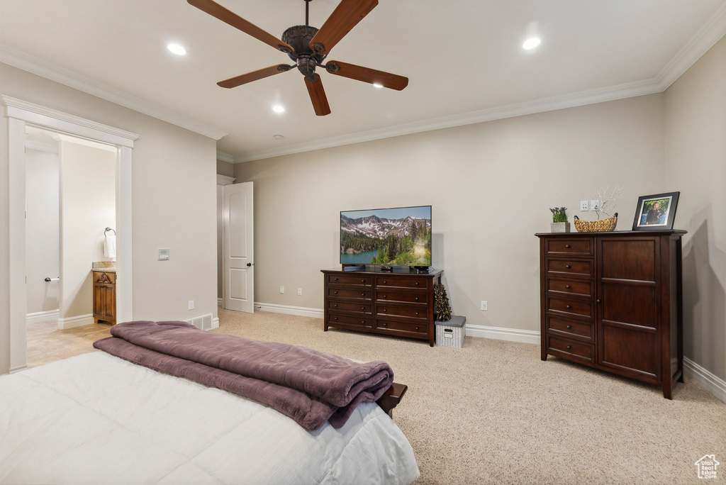 Bedroom featuring ornamental molding, ensuite bath, ceiling fan, and light colored carpet