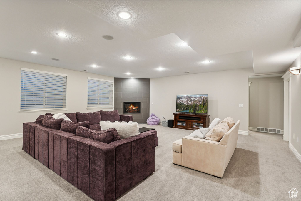 Carpeted living room featuring a tiled fireplace