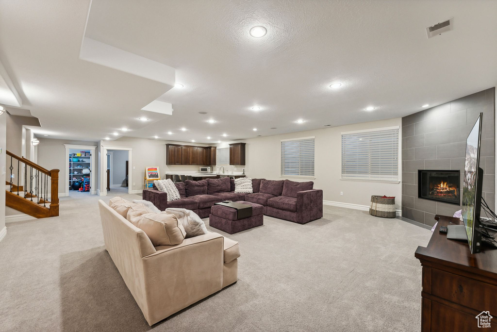 Carpeted living room featuring a textured ceiling and a fireplace