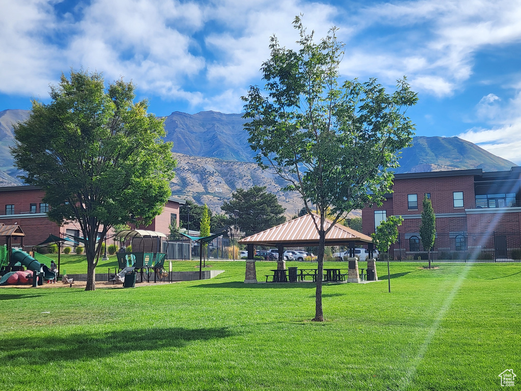 View of property\'s community featuring a playground, a gazebo, a yard, and a mountain view