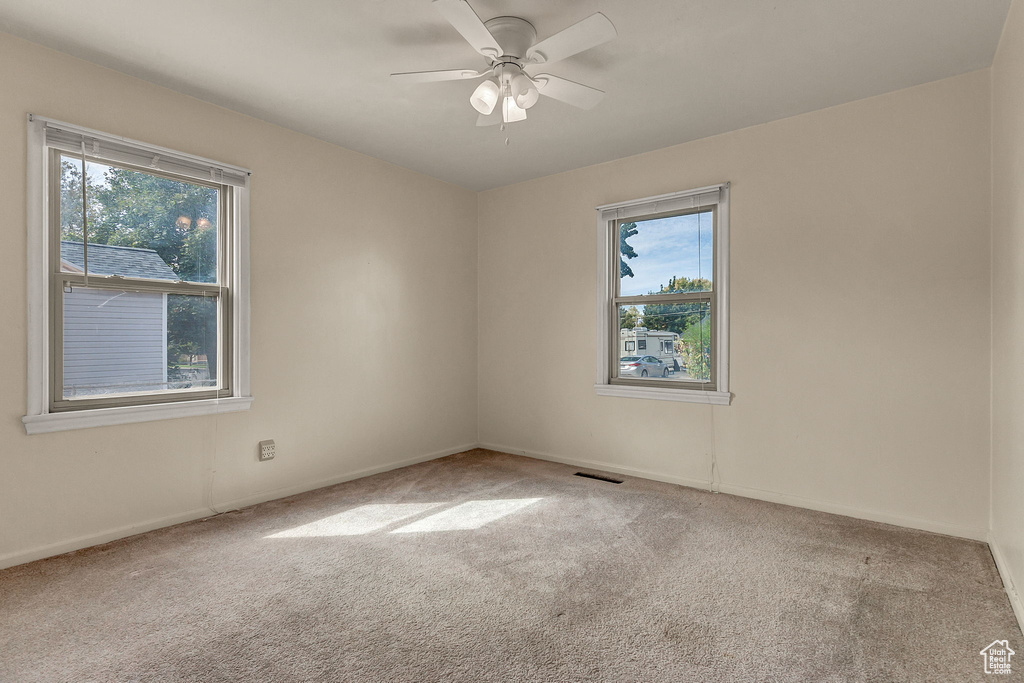 Spare room featuring ceiling fan and light colored carpet