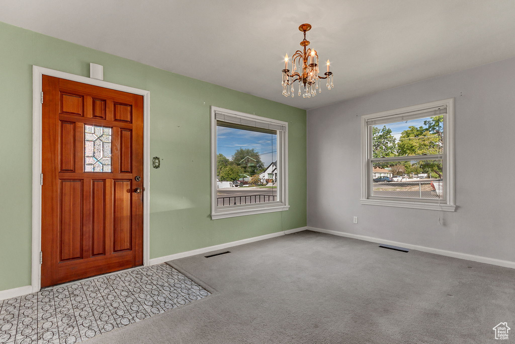 Entryway featuring carpet floors and an inviting chandelier