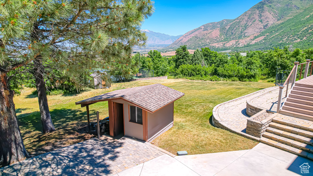 Exterior space featuring a shed, a mountain view, and a patio area