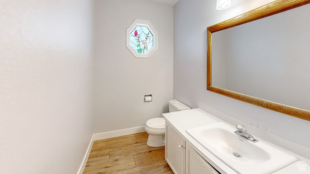 Bathroom featuring hardwood / wood-style floors, vanity, and toilet