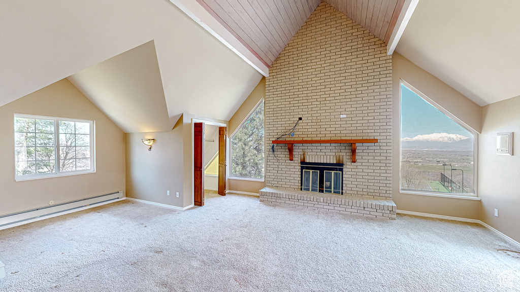 Unfurnished living room with a baseboard heating unit, a brick fireplace, vaulted ceiling with beams, and light colored carpet