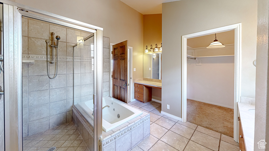 Bathroom with tile patterned flooring, independent shower and bath, and vanity