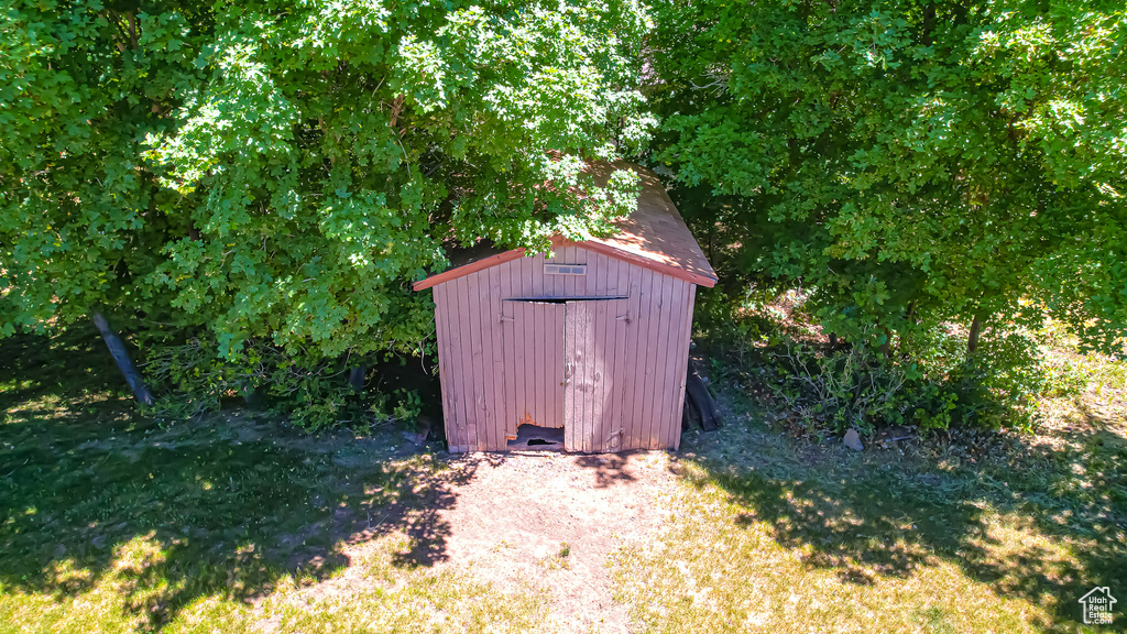 View of outbuilding featuring a lawn