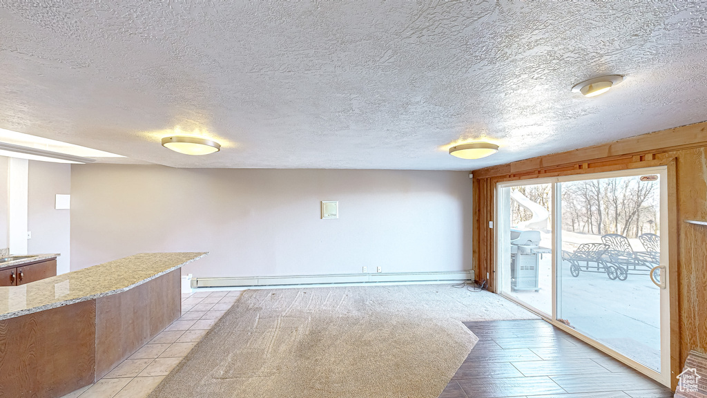 Carpeted spare room featuring a textured ceiling