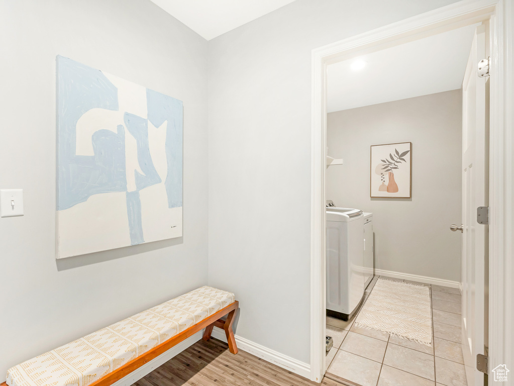 Laundry area with light tile patterned flooring and independent washer and dryer