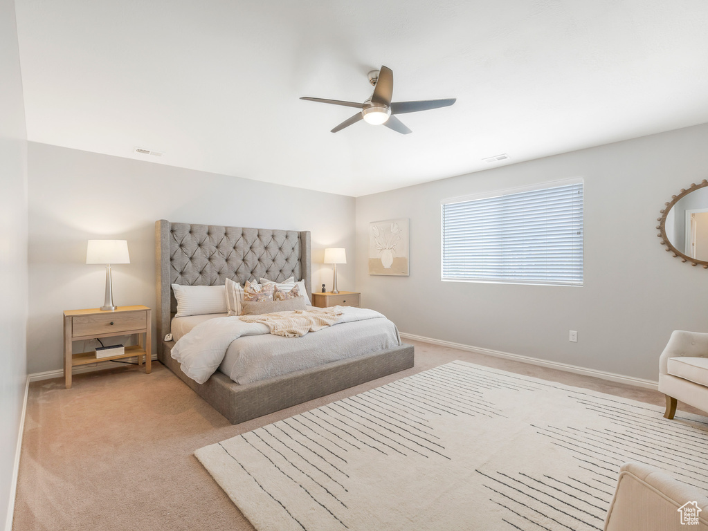 Carpeted bedroom featuring ceiling fan