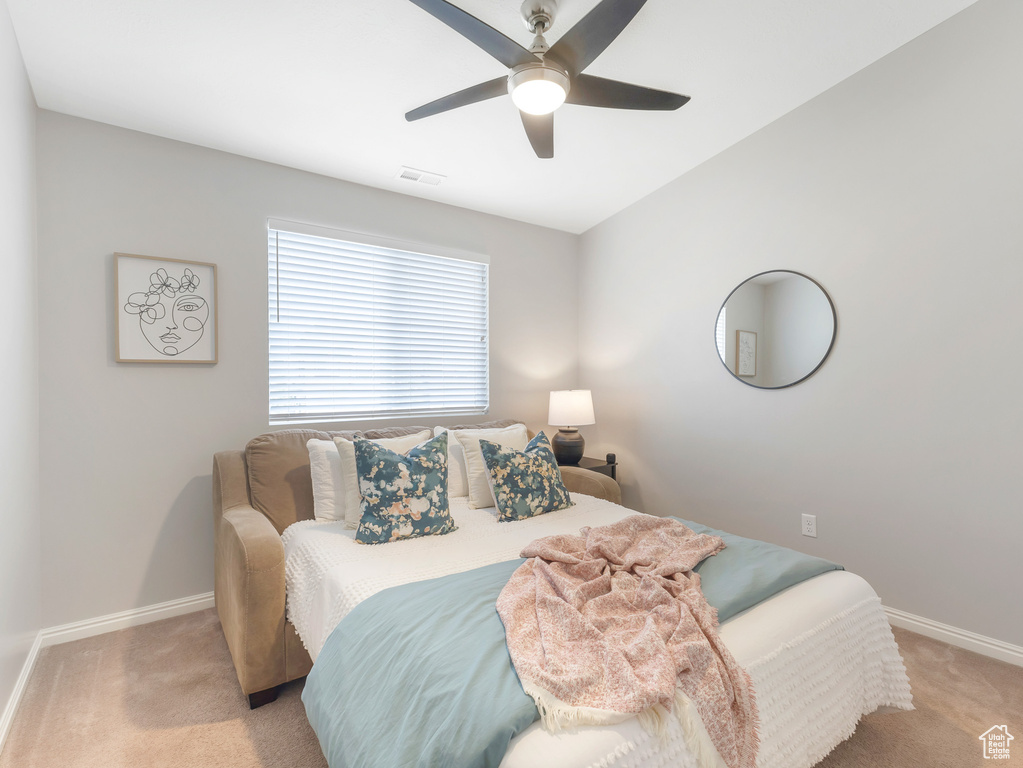 Bedroom with ceiling fan and light carpet