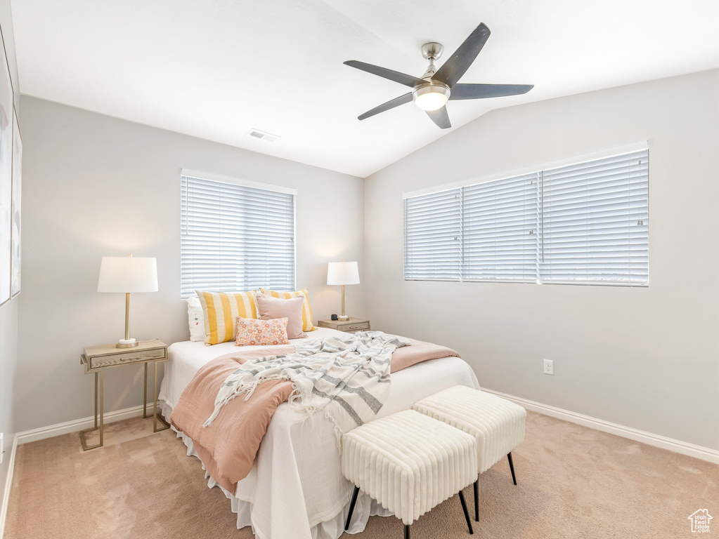 Carpeted bedroom with vaulted ceiling and ceiling fan