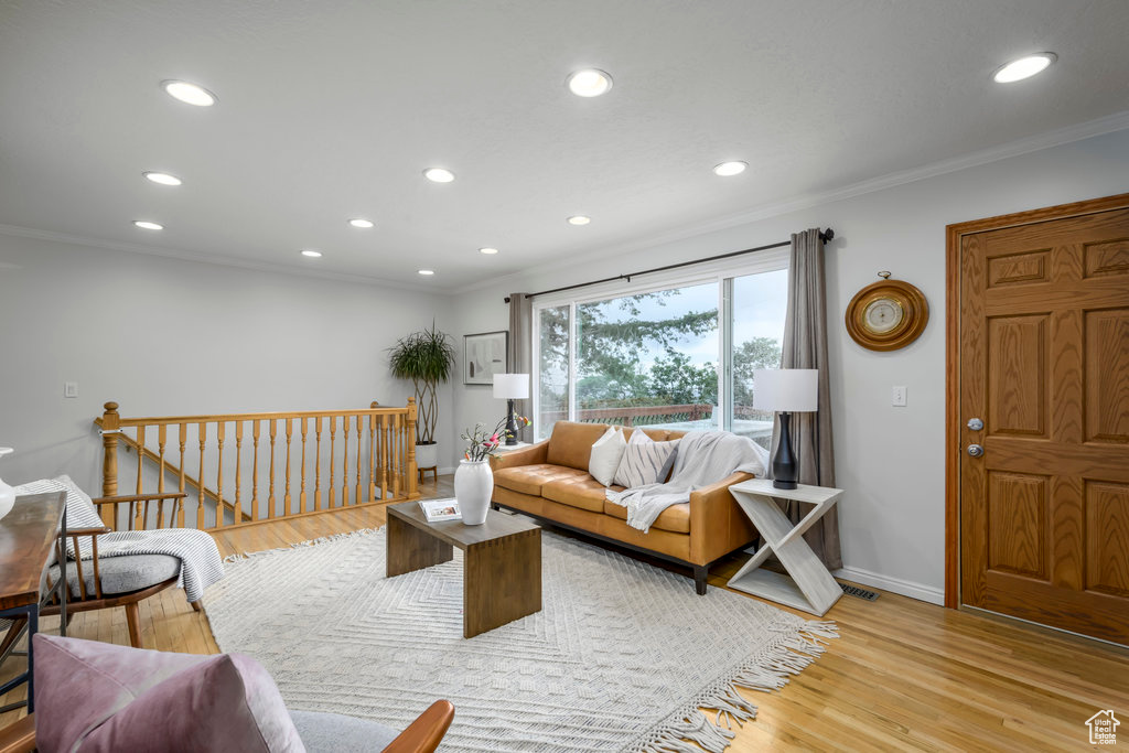 Living room featuring ornamental molding and light hardwood / wood-style floors