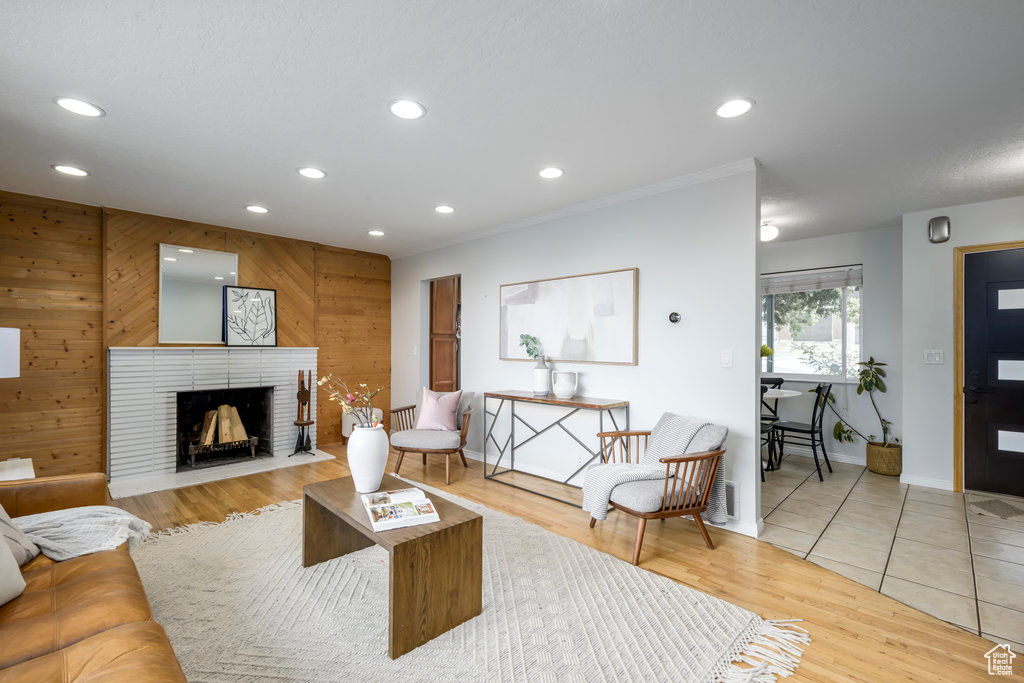 Living room featuring a brick fireplace, hardwood / wood-style flooring, and wooden walls