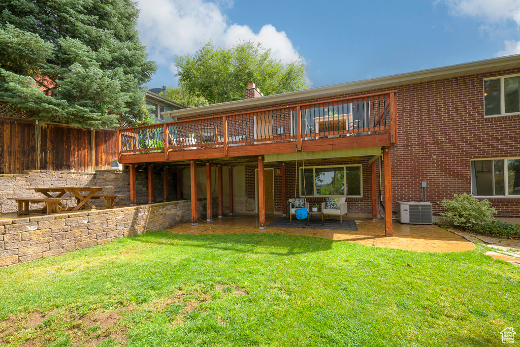 Back of house featuring a patio, a deck, a yard, and central AC unit