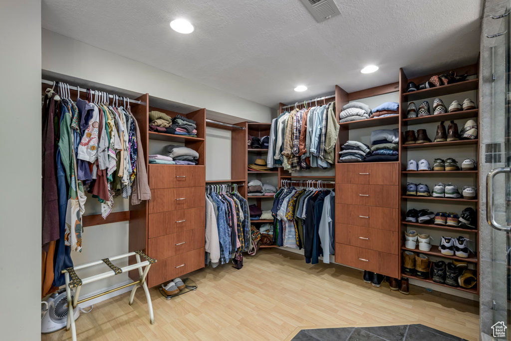 Spacious closet with light hardwood / wood-style flooring