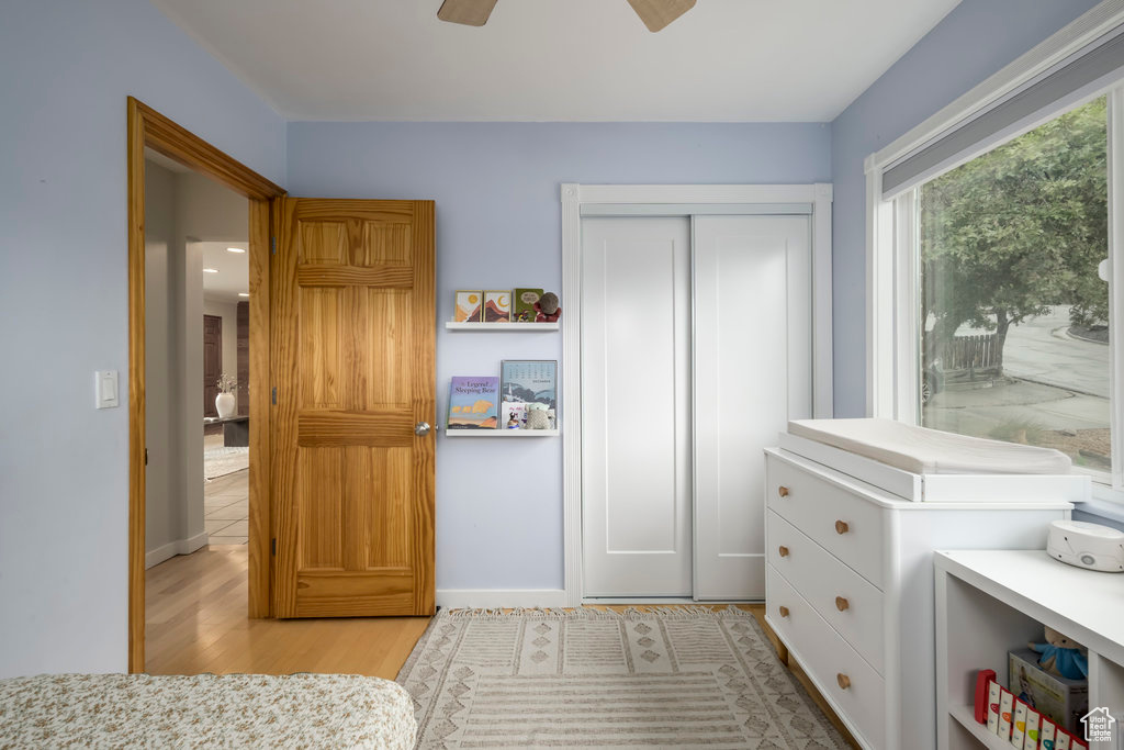 Bedroom featuring light hardwood / wood-style flooring, a closet, and ceiling fan