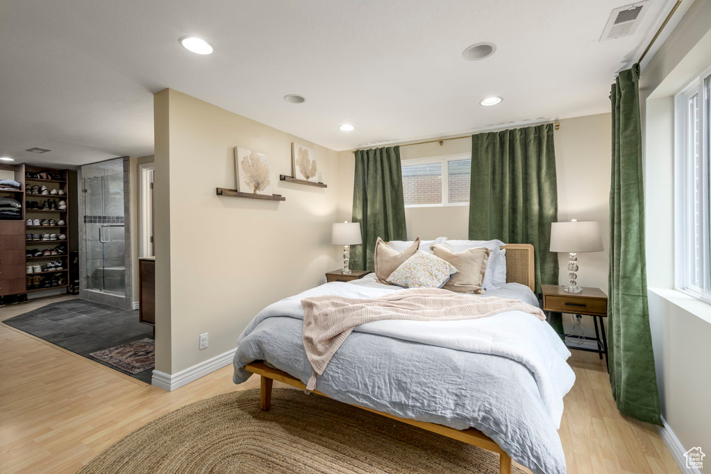 Bedroom featuring multiple windows and light hardwood / wood-style floors