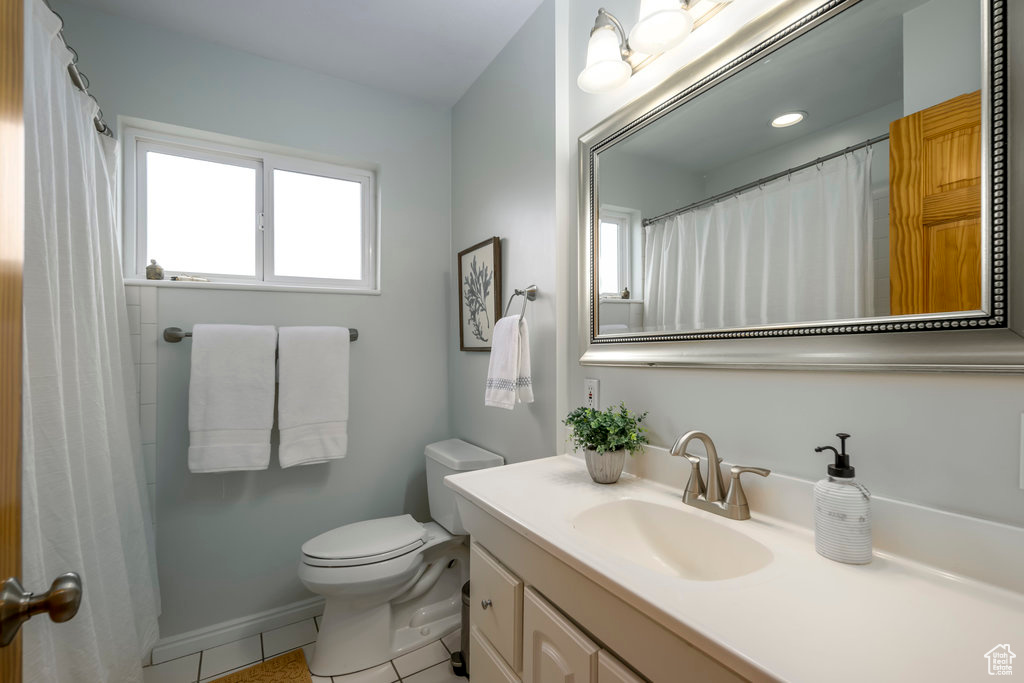 Bathroom featuring tile patterned flooring, vanity, and toilet