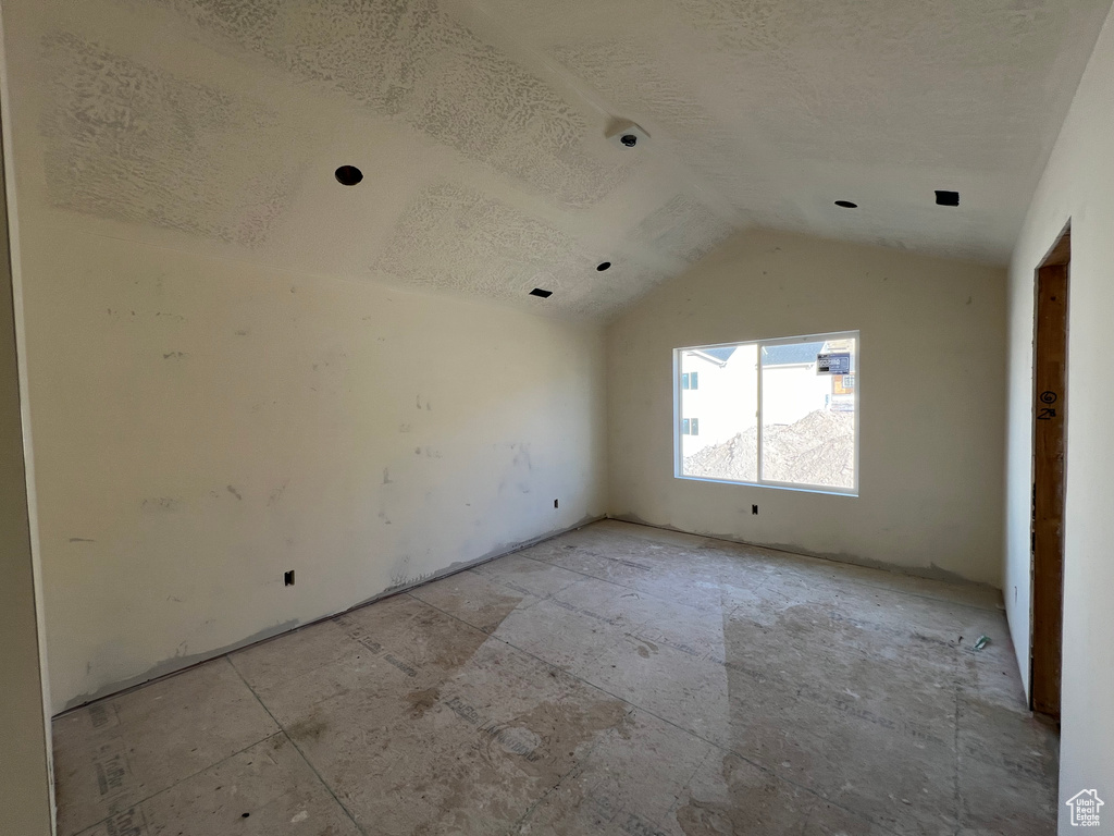 Empty room with lofted ceiling