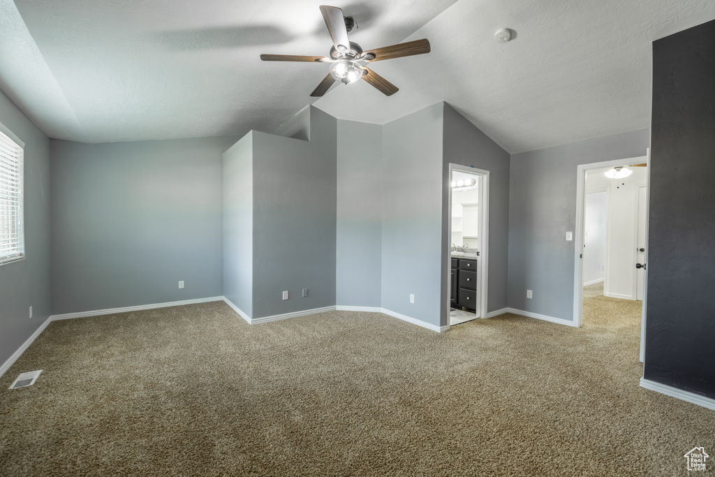 Unfurnished room featuring light carpet, lofted ceiling, and ceiling fan