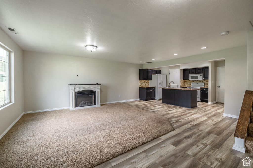 Unfurnished living room featuring a textured ceiling and hardwood / wood-style flooring