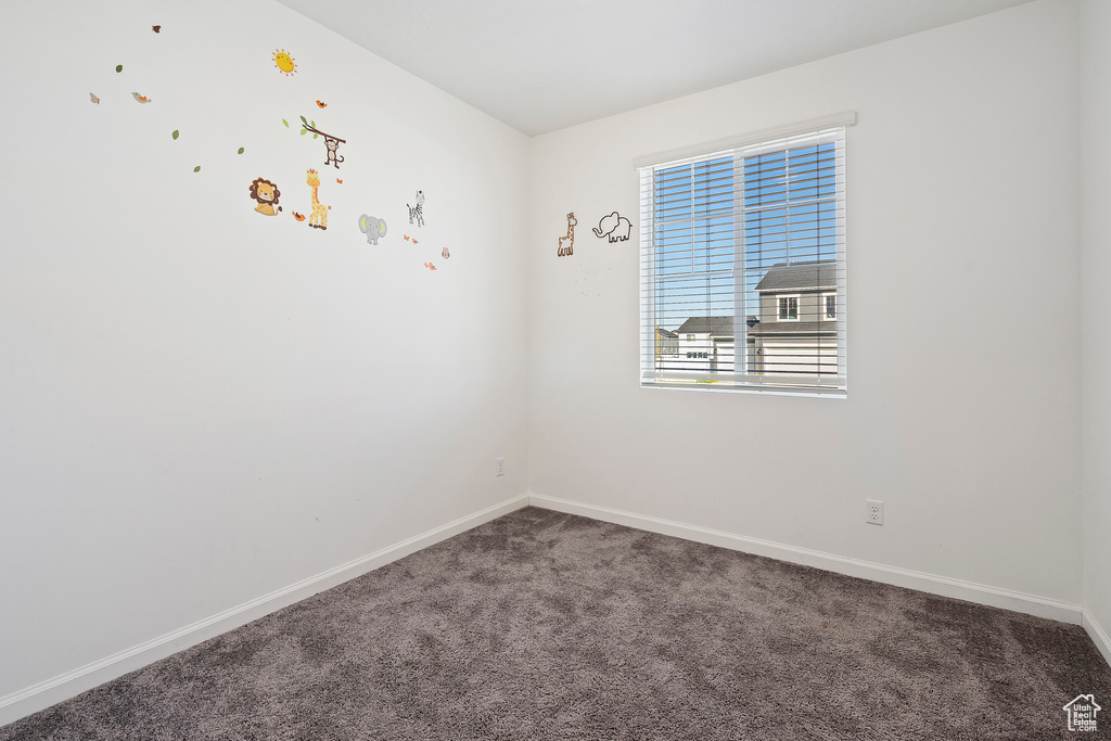 Empty room featuring dark carpet