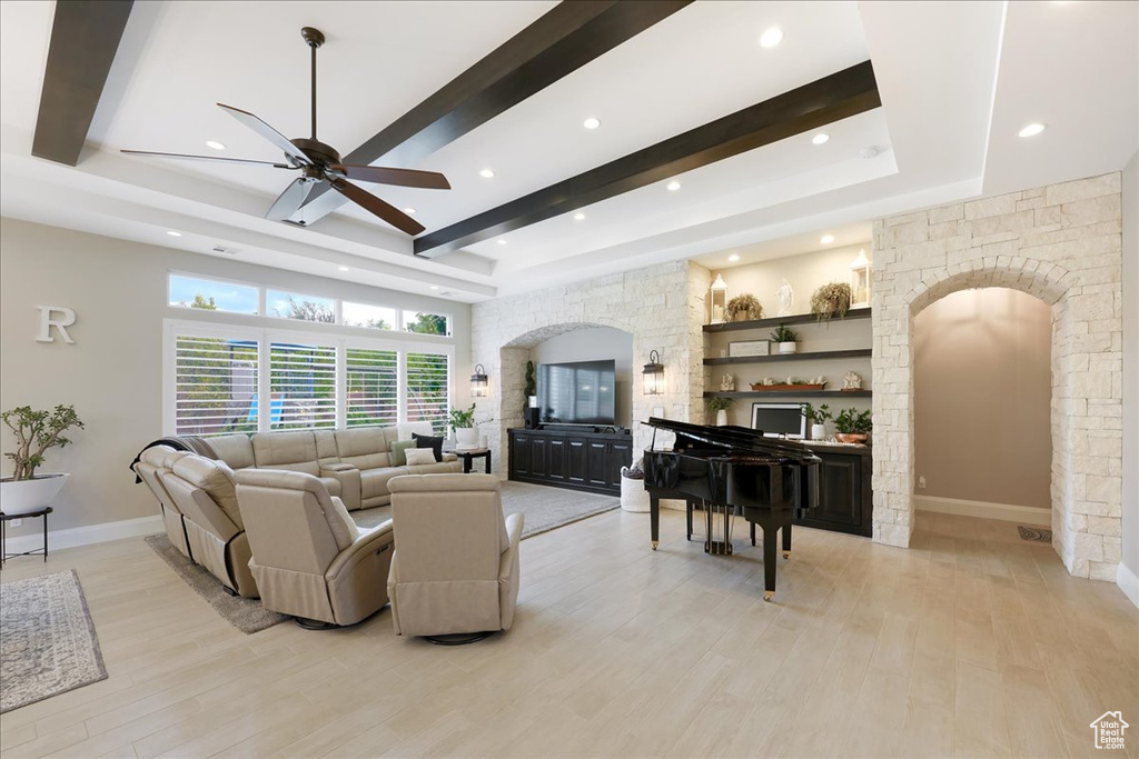 Living room featuring ceiling fan, beam ceiling, and light hardwood / wood-style floors