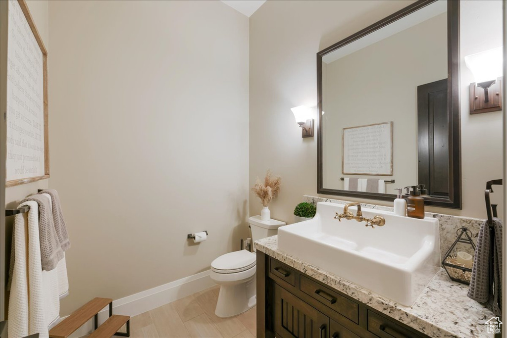 Bathroom featuring hardwood / wood-style flooring, vanity, and toilet