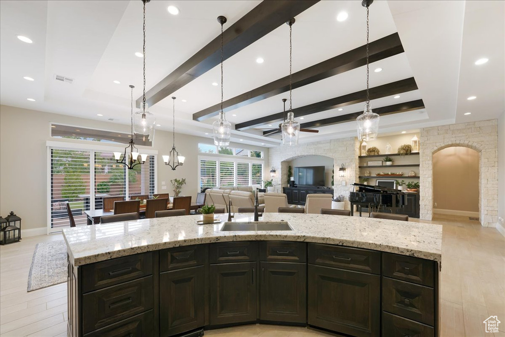 Kitchen featuring ceiling fan with notable chandelier, light hardwood / wood-style floors, and a wealth of natural light