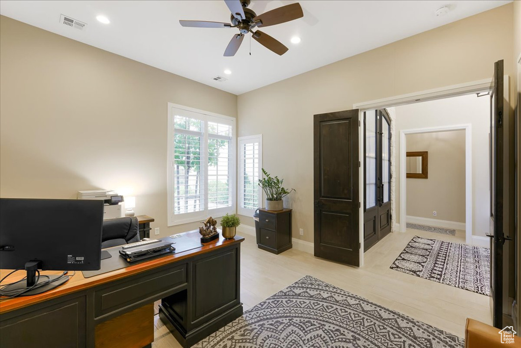 Home office featuring light hardwood / wood-style flooring and ceiling fan