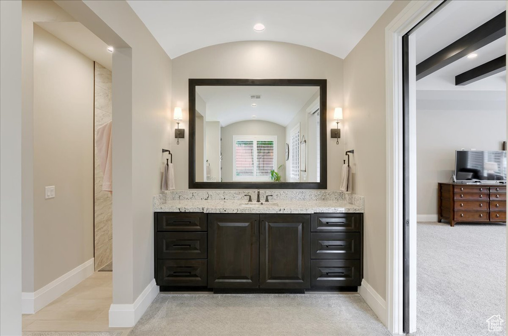 Bathroom featuring lofted ceiling and vanity