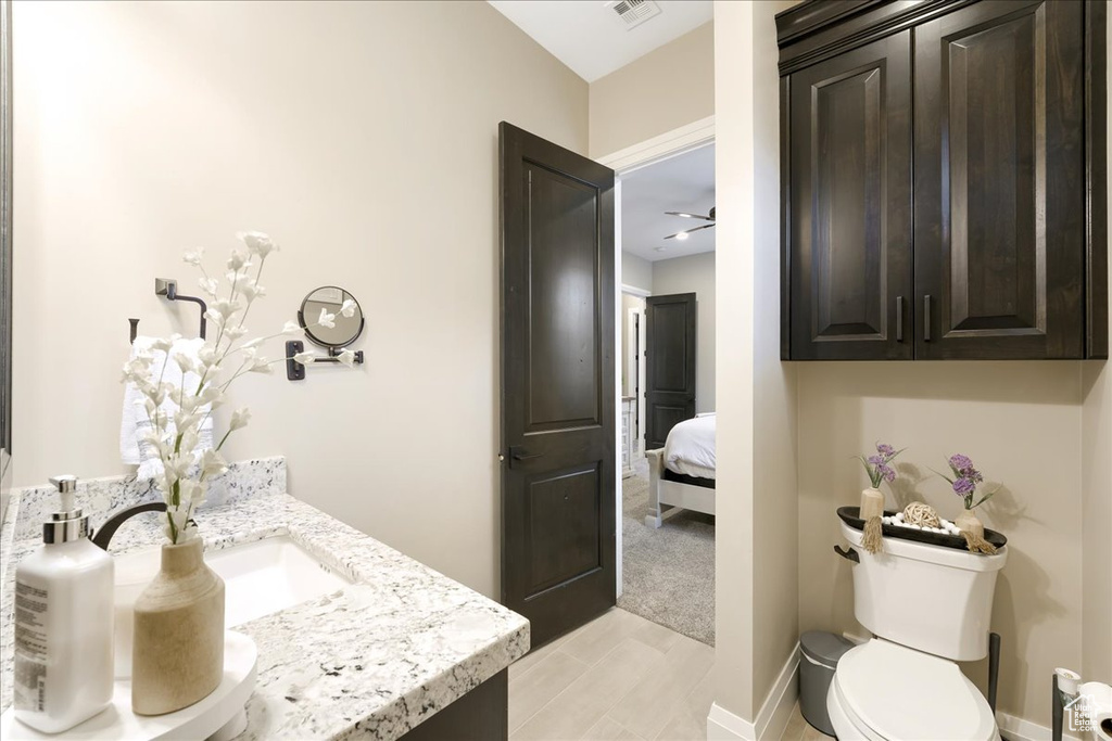 Bathroom with ceiling fan, vanity, and toilet