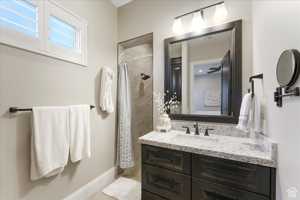 Bathroom with vanity, ceiling fan, and a shower with curtain