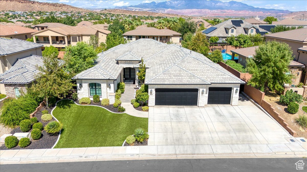 View of front of house with a mountain view and a front lawn