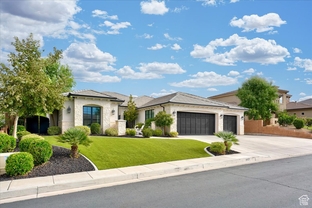 View of front of property featuring a garage and a front yard