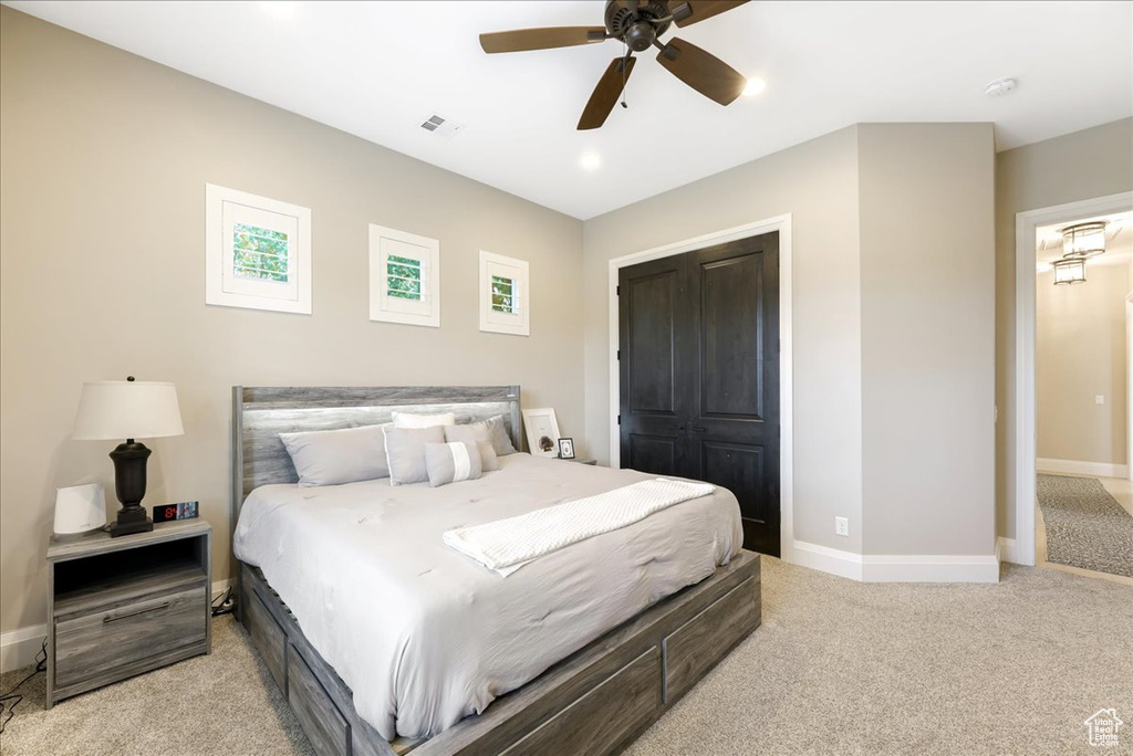 Carpeted bedroom featuring a closet and ceiling fan