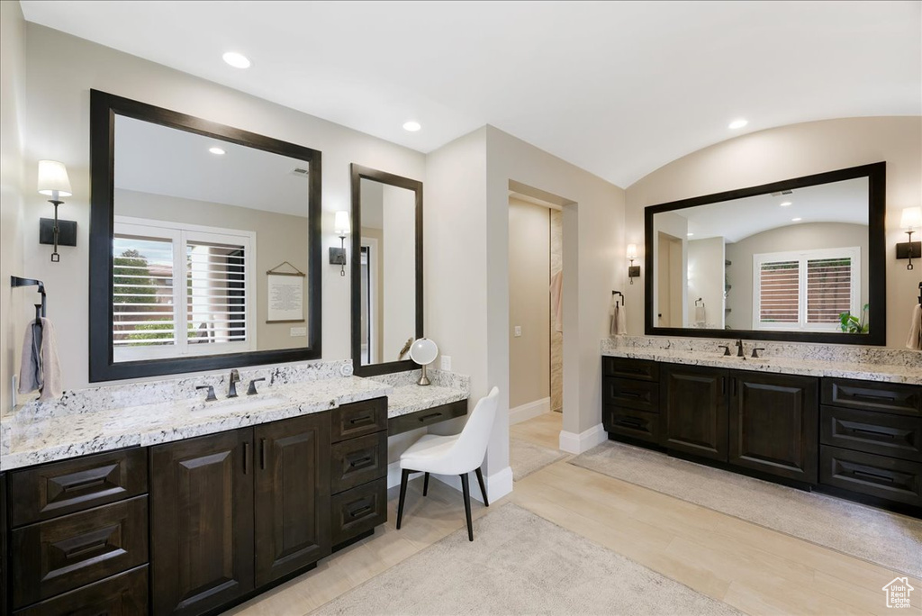 Bathroom with vanity, lofted ceiling, and hardwood / wood-style flooring