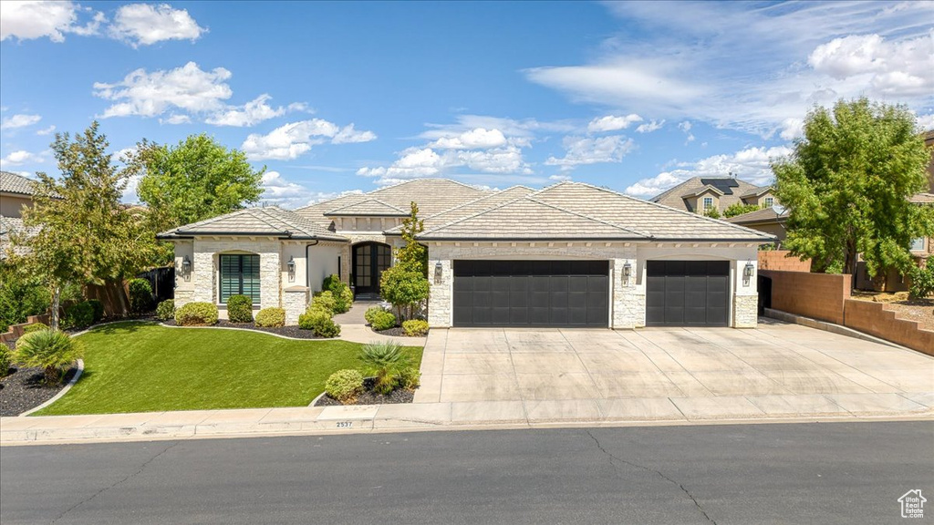 View of front facade featuring a garage and a front yard