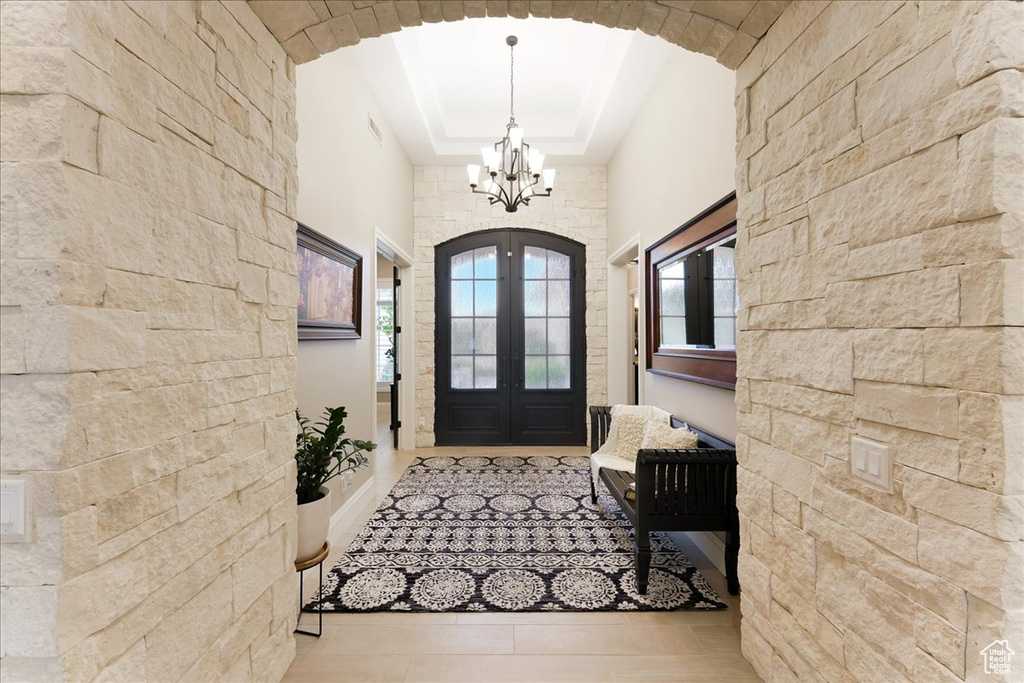 Foyer featuring a tray ceiling and an inviting chandelier