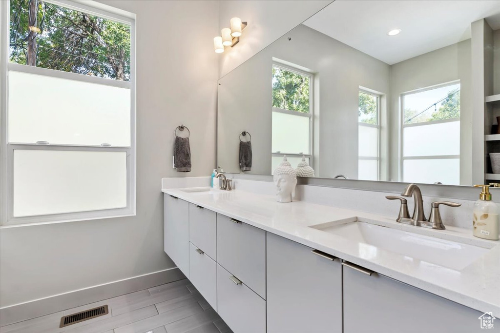 Bathroom with a healthy amount of sunlight, vanity, and hardwood / wood-style floors