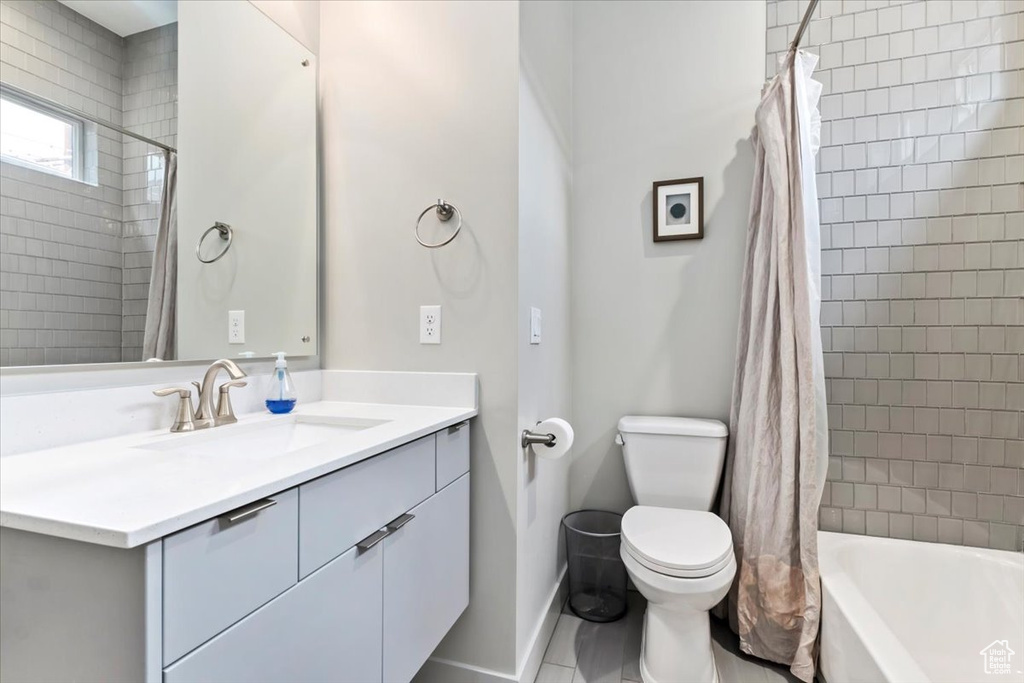 Full bathroom featuring vanity, tile patterned flooring, toilet, and shower / bathtub combination with curtain