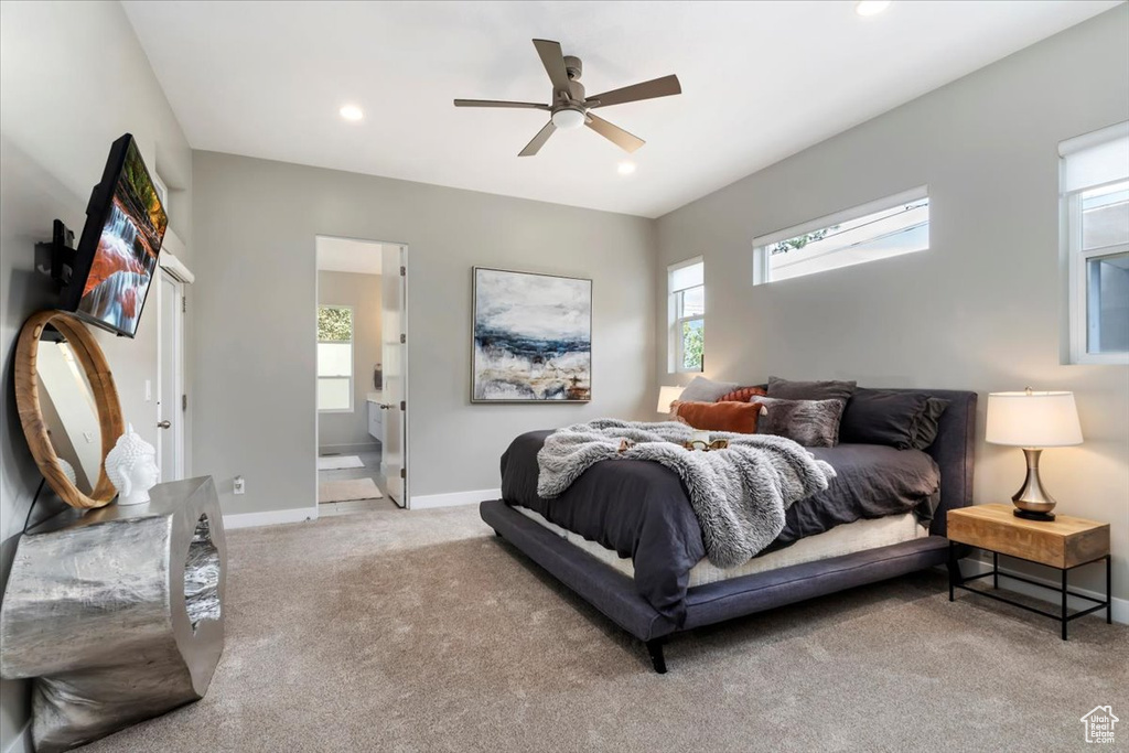 Bedroom featuring light carpet, ensuite bath, and ceiling fan