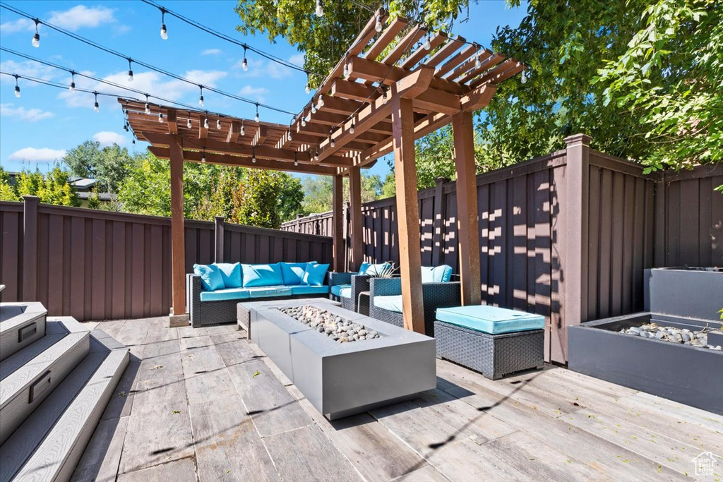 View of patio / terrace featuring a wooden deck, a pergola, and an outdoor living space with a fire pit