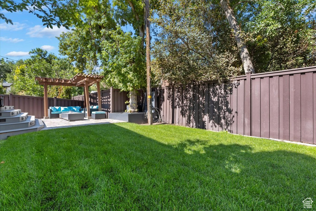 View of yard featuring an outdoor living space, a pergola, and a patio area