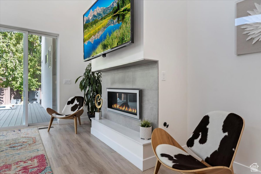 Living area with light wood-type flooring and a tile fireplace